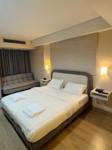 a hotel room with a large bed and a couch at Inspire place rama9 Modern Condo near Rajamangala Stadium Pool and Gym in Bangkok