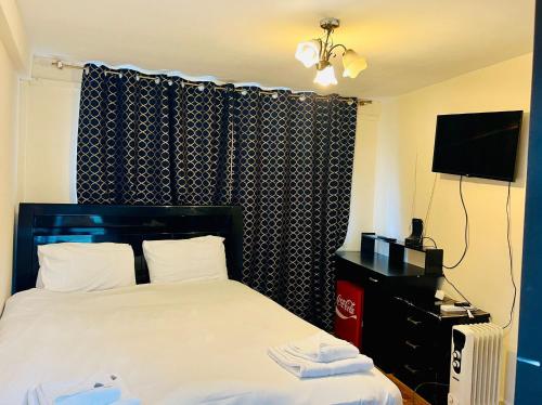 a hotel room with a bed and a television at The Bridge House Hotel in Reigate
