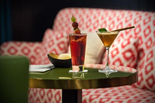 two cocktails sitting on a table with a chair at Vincci The Mint in Madrid