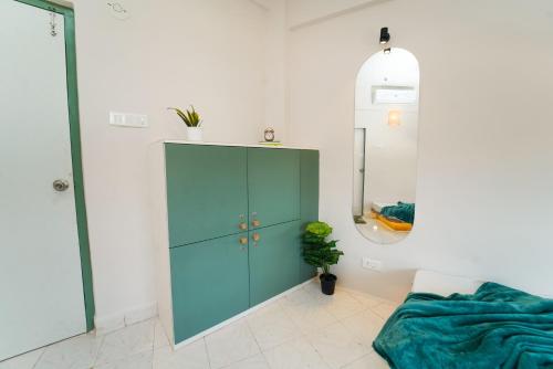 a room with a green cabinet and a mirror at Voyage Zo Lonavala in Lonavala