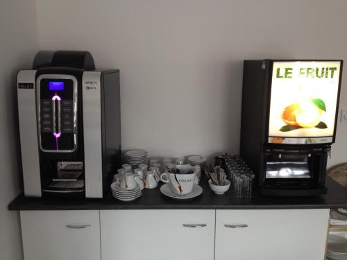 een aanrecht met een koffiezetapparaat en een magnetron bij Hôtel Le Saint Amand in Saint-Amand-Montrond