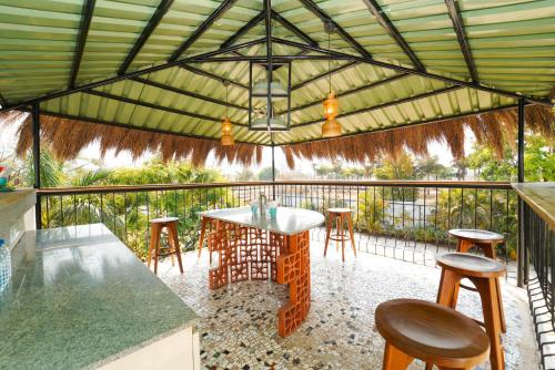 a gazebo with a table and stools on a patio at Voyage Zo Lonavala in Lonavala