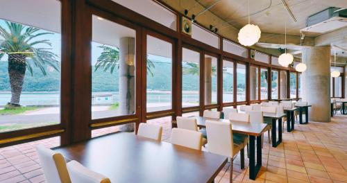 a dining room with tables and white chairs at アクアホテル小豆島リゾート in Shodoshima