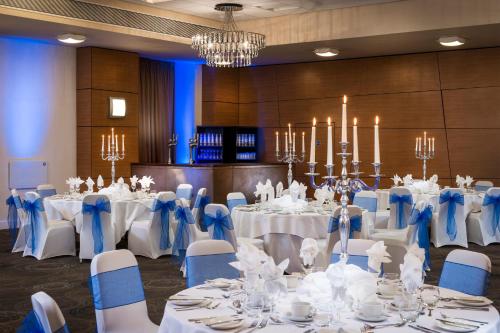 a banquet room with white tables and blue chairs at Park Inn by Radisson Palace in Southend-on-Sea