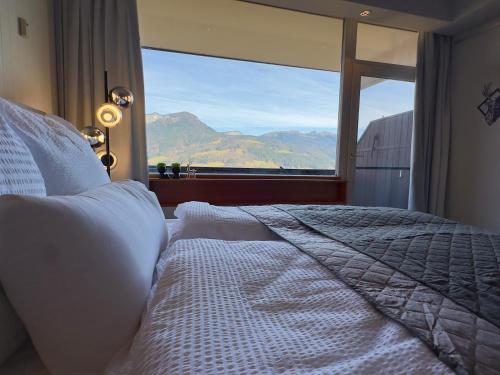 a bedroom with a bed and a large window at Bergträumerei in Bad Goisern