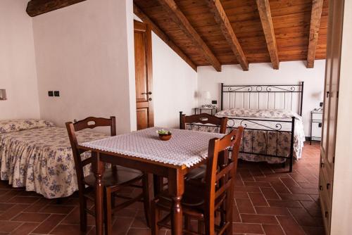 uma sala de jantar com uma mesa e 2 camas em La Meridiana Casale em Pignone