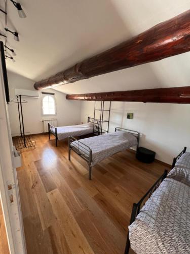 Cette chambre comprend 3 lits et du parquet. dans l'établissement villa 10 personnes au soleil, à Cavillargues