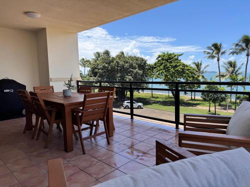 a dining room with a table and chairs on a balcony at Townsville Apartments and Homes on The Strand in Townsville