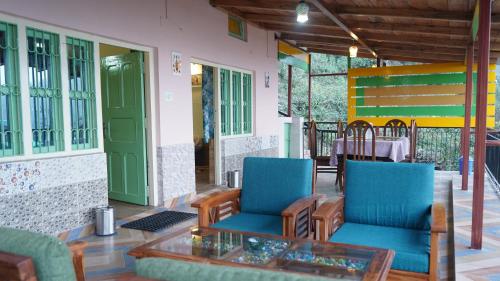 a porch with two chairs and a glass table at Luxsugero Moonlight in Bhīm Tāl