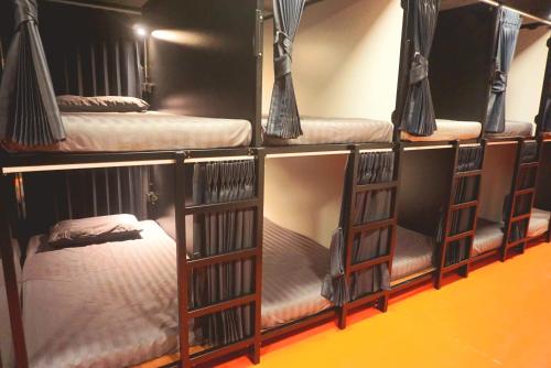 a group of four bunk beds in a room at Silom Soi 3 Hash Hostel in Bangkok