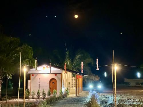 a small chapel at night with lights on at สวนปาล์มการ์เด้นโฮม เชียงคาน Suanpalm Garden Home Changkhan in Chiang Khan