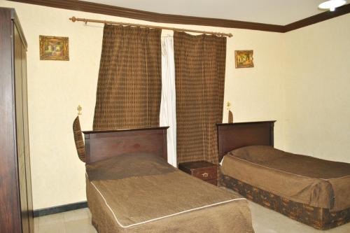 A bed or beds in a room at Golden Prince Hotel Al Fayizia