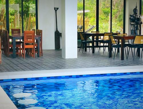 a swimming pool with tables and chairs in a restaurant at La Vida Bonita Bed and Breakfast in San Vicente