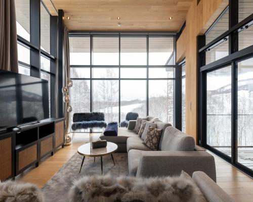 a living room with a couch and a tv at Kazahana at Hanaridge in Kutchan