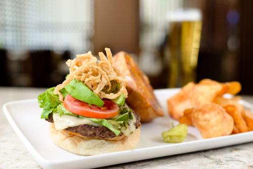 a white plate with a sandwich and french fries at Hilton Woodland Hills/ Los Angeles in Woodland Hills