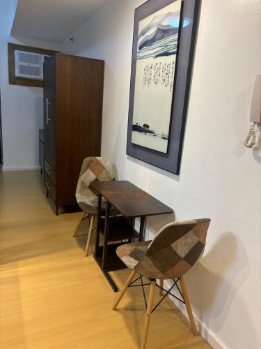 a dining room with a table and two chairs at Cozy studio unit in Avant BG in Manila