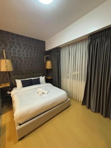a bedroom with a large bed and a window at Cozy studio unit in Avant BG in Manila