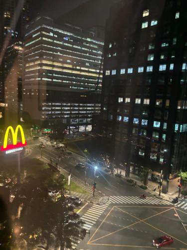 a view of a city at night with a mcdonalds sign at Cozy studio unit in Avant BG in Manila