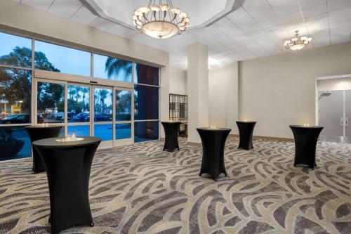 a large room with black tables and windows at Embassy Suites by Hilton Anaheim South in Anaheim