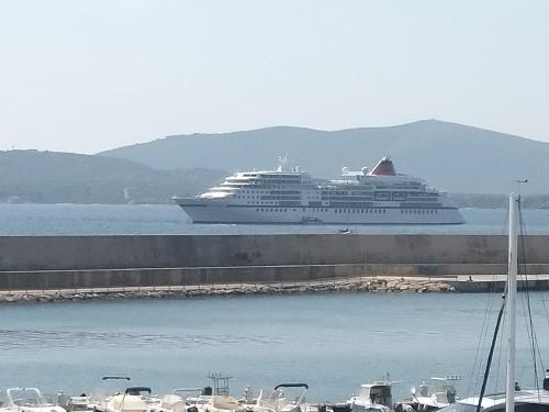 a large cruise ship is docked in the water at Sardinia rooms in Alghero