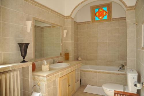 a bathroom with a sink and a tub and a toilet at Villa Valflor chambres d'hôtes et appartements in Marseille