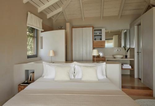 a bedroom with a large white bed with white pillows at F ZEEN Kefalonia in Lourdhata
