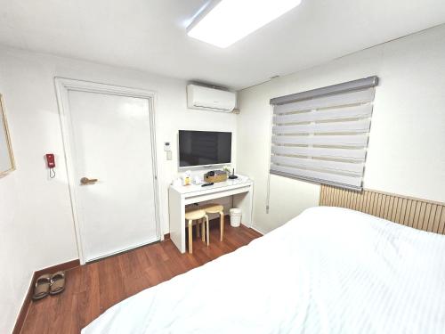 a bedroom with a bed and a desk with a television at Seoul Nest in Seoul