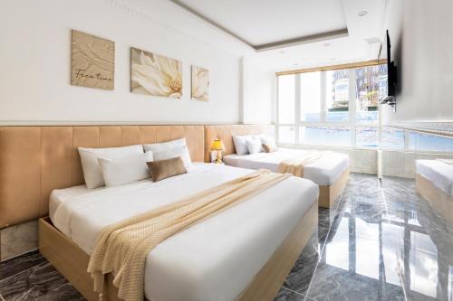 a hotel room with two beds and a couch at Nghia Lan Hotel in Da Lat