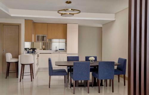 a kitchen and dining room with a table and chairs at Hilton Bahrain City Centre Hotel & Residences in Manama