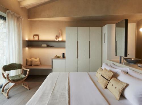 a bedroom with a large bed and a chair at F ZEEN Kefalonia in Lourdhata