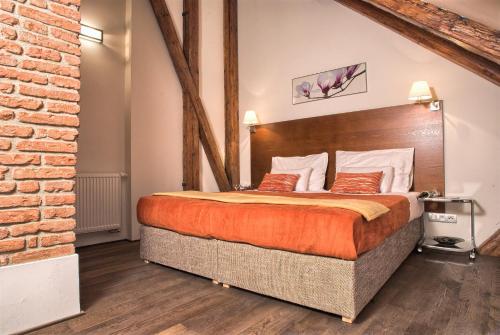 プラハにあるResidence Rybnaのレンガの壁の客室で、大型ベッド1台を利用できます。