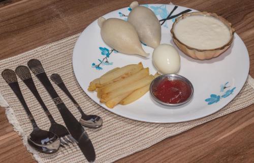 a plate with eggs and french fries on a table at organic healing home in Pātan