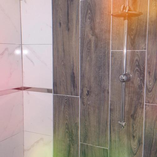 a shower with a wooden door in a bathroom at Samlife Apart in Samsun