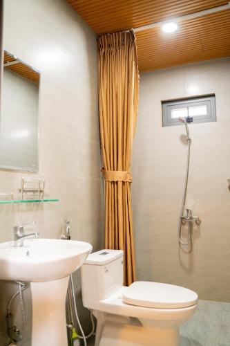 a bathroom with a toilet and a sink at Tĩnh Lạc Viên Homestay Bảo lộc in Bao Loc
