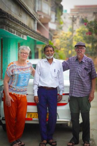 three people standing in front of a bus at Risabya Guest House in Gājol
