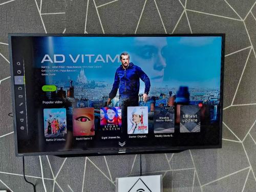 a tv hanging on a wall with a picture of a man at Grand Horizon Imperium Residence Kuantan Studio City view in Kuantan