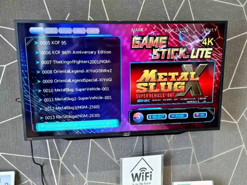a tv hanging on a wall with a video game sign at Grand Horizon Imperium Residence Kuantan Studio City view in Kuantan