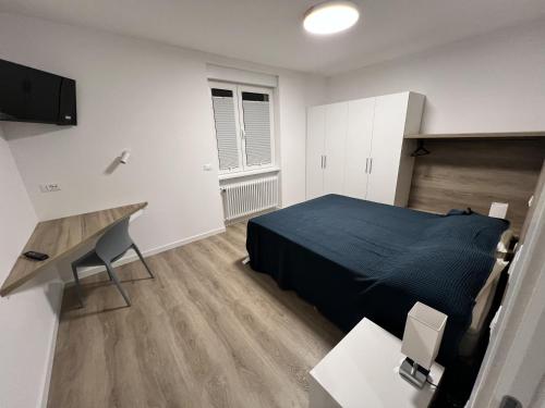 a bedroom with a bed and a desk and a television at MARY Apartment in Tarvisio