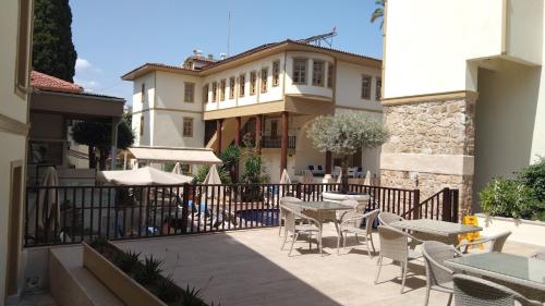 a patio with tables and chairs in front of a building at Puding Hotel in Antalya