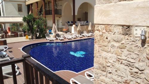 a swimming pool with chaise lounge chairs next to a building at Puding Hotel in Antalya