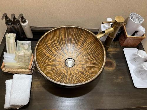a gold sink on a counter with other bathroom items at Oyado Koto No Yume in Takayama