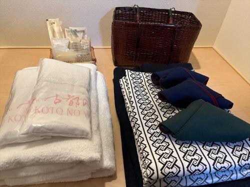 two towels and a basket are sitting on a floor at Oyado Koto No Yume in Takayama