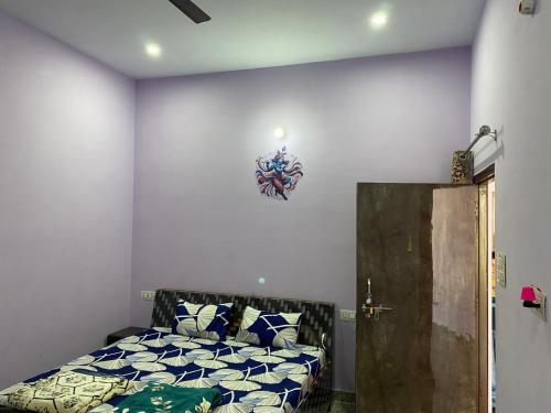 a bedroom with a bed and a wall at Upvan in Vrindāvan