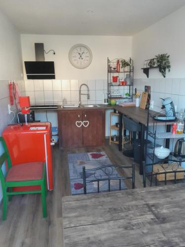 a kitchen with a sink and a table with a clock on the wall at Ferienwohnung Auszeit in Aue