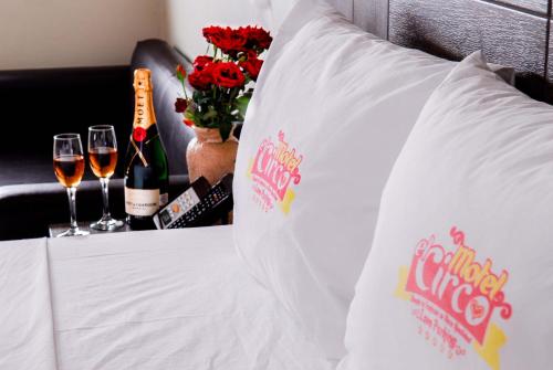 uma cama com dois copos de vinho e flores em Motel el Circo em San Pablo Etla