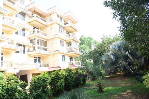 a large yellow building with trees in front of it at Dona Rosa Holiday Apartment in Varca