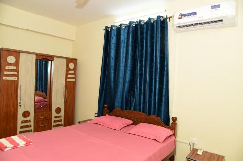 a bedroom with a pink bed and a blue curtain at Dona Rosa Holiday Apartment in Varca