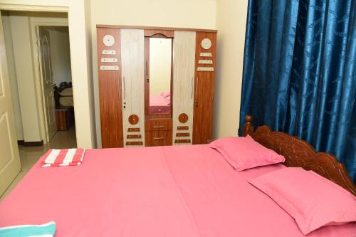 a bedroom with a bed with a pink comforter at Dona Rosa Holiday Apartment in Varca