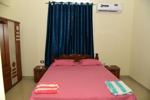 a bedroom with a pink bed with a blue curtain at Dona Rosa Holiday Apartment in Varca