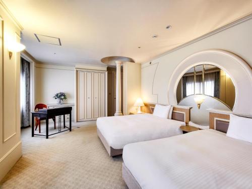 a hotel room with two beds and a desk at Royal Pines Hotel Chiba- Opening in Jan 2025 in Chiba
